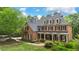 Beautiful brick home with black shutters, a covered front porch, and lush landscaping at 120 Burford Holw, Alpharetta, GA 30022