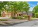 Charming brick home showcasing a three-car garage, manicured lawn, and inviting covered front porch at 120 Burford Holw, Alpharetta, GA 30022