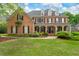 Elegant brick residence boasts a well-manicured lawn and a covered front porch perfect for relaxing at 120 Burford Holw, Alpharetta, GA 30022