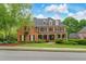 Attractive brick home with a covered porch and manicured front lawn, enhancing curb appeal at 120 Burford Holw, Alpharetta, GA 30022