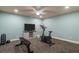 Dedicated home gym with an exercise bike, bench, weights, and a mounted television at 120 Burford Holw, Alpharetta, GA 30022