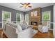 Comfortable living room with a stone fireplace, large windows, and hardwood floors at 120 Burford Holw, Alpharetta, GA 30022