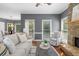 Inviting living room featuring a stone fireplace, ample natural light, and gray accent walls at 120 Burford Holw, Alpharetta, GA 30022