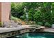 Gorgeous pool area with lounge chairs, landscaped terraces, and mature trees offers a serene retreat at 120 Burford Holw, Alpharetta, GA 30022