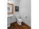 Classic powder room with pedestal sink, hardwood floor, and elegant wall decor at 120 Burford Holw, Alpharetta, GA 30022