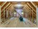 Unfinished attic space with exposed beams and plywood flooring offering customization and expansion possibilities at 335 Cameron Ridge Dr, Atlanta, GA 30328