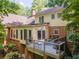 Backyard view of the home featuring an elevated deck, patio furniture, brick facade, and mature trees at 335 Cameron Ridge Dr, Atlanta, GA 30328