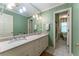 Bright bathroom showcasing a double vanity, large mirror, decorative wallpaper, and walk-in shower at 335 Cameron Ridge Dr, Atlanta, GA 30328