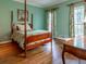Green painted bedroom with hardwood floors, four-poster bed, and large windows at 335 Cameron Ridge Dr, Atlanta, GA 30328