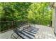 Backyard view of a deck with wooded area, patio furniture, black railing, and white painted floor at 335 Cameron Ridge Dr, Atlanta, GA 30328
