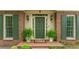 Inviting front entrance featuring a classic green door, decorative sconces, and lush ferns, creating a welcoming ambiance at 335 Cameron Ridge Dr, Atlanta, GA 30328