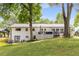 Rear exterior view of a house with a deck overlooking a lawn and mature trees at 3890 Cherrydale Se Ln, Smyrna, GA 30082