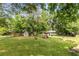 Expansive backyard featuring lush greenery, a storage shed, and a playset surrounded by mature trees at 3890 Cherrydale Se Ln, Smyrna, GA 30082