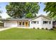Charming one-story home with a well-manicured lawn, bright yellow door, and an attached two car garage at 3890 Cherrydale Se Ln, Smyrna, GA 30082