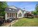 View of the backyard featuring outdoor seating, a grassy lawn, and mature trees on a sunny day at 4503 Woodhaven Ne, Marietta, GA 30067