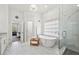 Bright bathroom features a soaking tub and glass shower enclosure, illuminated by elegant lighting at 4503 Woodhaven Ne, Marietta, GA 30067