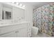Bright bathroom with a floral shower curtain, a white vanity, and ample counter space at 4503 Woodhaven Ne, Marietta, GA 30067
