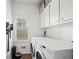 Efficient laundry room with white cabinets, modern appliances, and a window for natural light and ventilation at 4503 Woodhaven Ne, Marietta, GA 30067