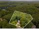 Aerial view of a private, wooded lot with a charming house nestled among the trees at 5560 Pilgrim Point Ext, Cumming, GA 30041