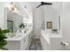 Bright bathroom featuring double sink vanity, soaking tub, and luxury gold fixtures at 5560 Pilgrim Point Ext, Cumming, GA 30041