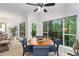 Bright dining area with a wooden table, blue chairs, and large windows with a scenic view of the outdoors at 5560 Pilgrim Point Ext, Cumming, GA 30041