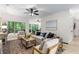 Bright living room featuring hardwood floors, neutral furnishings, and large windows showcasing the wooded scenery at 5560 Pilgrim Point Ext, Cumming, GA 30041