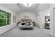 Spacious main bedroom with vaulted ceilings, a large window overlooking the yard, and neutral decor at 5560 Pilgrim Point Ext, Cumming, GA 30041