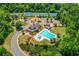 Aerial view of a community clubhouse, pool, playground, and tennis courts surrounded by lush trees at 5960 Bridge Stone Ct, Cumming, GA 30028