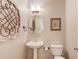 Half bathroom featuring a pedestal sink, toilet, and decorative wall art at 5960 Bridge Stone Ct, Cumming, GA 30028