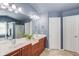 Bathroom features a double vanity with wood cabinets, soaking tub, and glass-enclosed shower at 5960 Bridge Stone Ct, Cumming, GA 30028