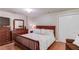 Well-lit bedroom featuring a wooden bed frame, dresser, and a closet at 5960 Bridge Stone Ct, Cumming, GA 30028