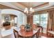 Dining room featuring hardwood floors, chandelier, and a view of the office area at 5960 Bridge Stone Ct, Cumming, GA 30028