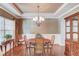 Elegant dining room with hardwood floors, chandelier, wainscoting, and ample natural light at 5960 Bridge Stone Ct, Cumming, GA 30028