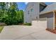 Exterior view of the garage and driveway, surrounded by mature trees and landscaping at 5960 Bridge Stone Ct, Cumming, GA 30028