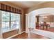 Elegant living room with hardwood floors, large window, and arched entrance to the formal dining room at 5960 Bridge Stone Ct, Cumming, GA 30028