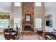 Cozy living room with stone fireplace, hardwood floors, and comfortable leather seating at 5960 Bridge Stone Ct, Cumming, GA 30028
