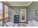 Charming sunroom with gray paneling, floral accents, and comfortable wicker furniture at 5960 Bridge Stone Ct, Cumming, GA 30028