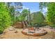 Large backyard featuring a brick fire pit, bocce court, and wooden deck, perfect for entertaining guests at 220 Hillswick Ct, Atlanta, GA 30328