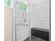Modern tiled shower featuring a glass door, contrasting black tile accents and seating bench at 220 Hillswick Ct, Atlanta, GA 30328