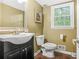 Neutral colored half bathroom with a black vanity, window, and framed art at 220 Hillswick Ct, Atlanta, GA 30328