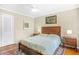 Warm bedroom with a queen-sized bed, hardwood floors, soft lighting, and stylish decor at 220 Hillswick Ct, Atlanta, GA 30328