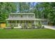 Charming two-story home features a lush green lawn and inviting front porch perfect for relaxing and enjoying the outdoors at 220 Hillswick Ct, Atlanta, GA 30328