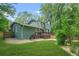 Back of a two-story home with large deck, well-manicured lawn, and fenced yard overlooking a wooded area at 220 Hillswick Ct, Atlanta, GA 30328