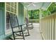 Cozy covered front porch with rocking chairs, offering a relaxing outdoor space with views of the surrounding lush greenery at 220 Hillswick Ct, Atlanta, GA 30328