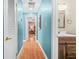 Hallway featuring wood floors, turquoise walls, and a view of the bathroom and bedroom at 220 Hillswick Ct, Atlanta, GA 30328