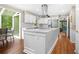 Bright kitchen features white cabinets, stainless appliances, an island, and an adjoining sunroom at 220 Hillswick Ct, Atlanta, GA 30328