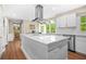 Bright kitchen features white cabinets, stainless appliances, an island, and an adjoining sunroom at 220 Hillswick Ct, Atlanta, GA 30328