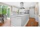 Bright kitchen features white cabinets, stainless appliances, an island, and an adjoining sunroom at 220 Hillswick Ct, Atlanta, GA 30328