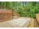 Backyard patio featuring an upper deck area, gravel and concrete landscaping, mature trees, and privacy fence at 220 Hillswick Ct, Atlanta, GA 30328