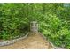 A quaint shed nestled among lush greenery, with a stone pathway and surrounded by mature trees at 220 Hillswick Ct, Atlanta, GA 30328